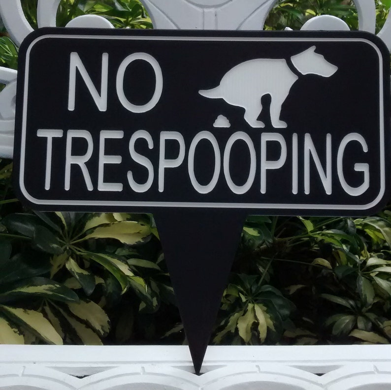 Op de afbeelding: Een zwart-wit bord met de tekst "NO TRESPOOPING" en een silhouet van een hond die poept.