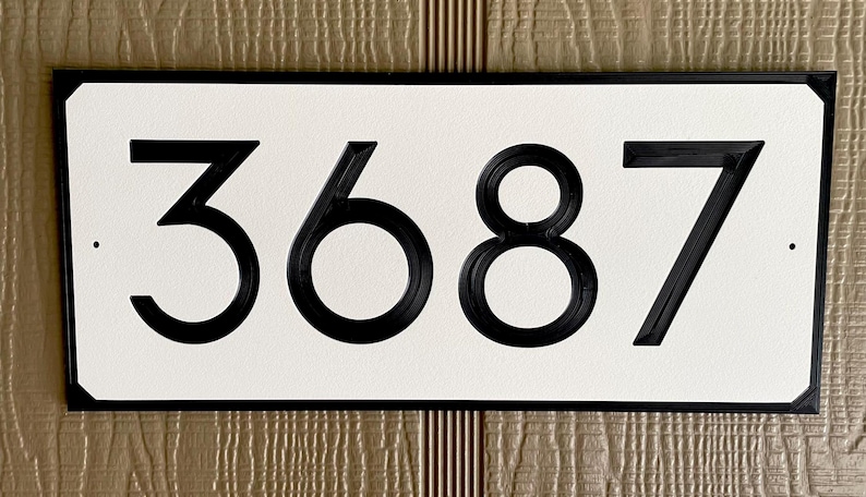 Pode incluir: Placa de n&uacute;mero de casa preta com fundo branco e o n&uacute;mero 3687 em preto.