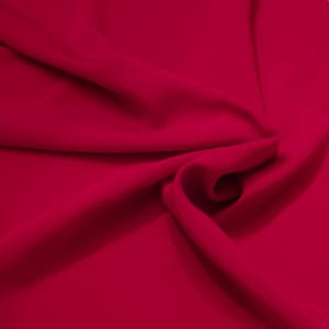 Könnte beinhalten: Nahaufnahme eines glatten, tief roten Stoffes mit weichen Falten und Knittern.