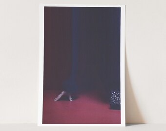 May include: A close-up of a hand reaching out on a red surface. A black box with white accents is in the background.