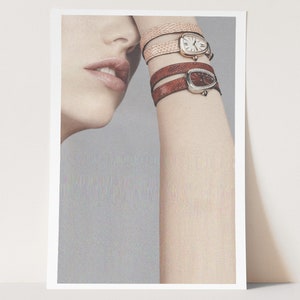 May include: A woman's wrist with three watches stacked on top of each other. The watches have brown leather bands and oval-shaped faces. The top watch has a white face, the middle watch has a brown face, and the bottom watch has a black face.