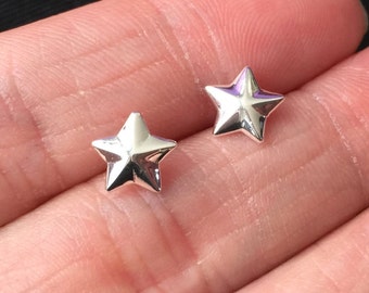 May include: A pair of silver star-shaped stud earrings.