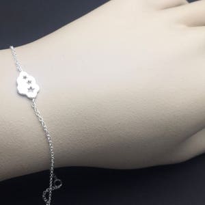 May include: A silver chain bracelet with a cloud charm featuring three star cutouts.