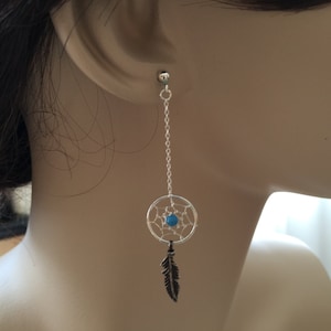 May include: Silver dangle earrings with a turquoise dreamcatcher charm and a feather pendant.