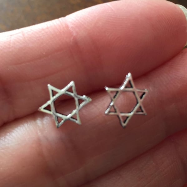 May include: A pair of silver Star of David earrings. The earrings are small and delicate, and they are perfect for everyday wear.