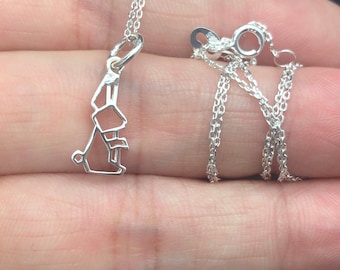 May include: A silver chain necklace with a delicate, geometric rabbit pendant.