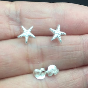 May include: A pair of silver starfish stud earrings. The earrings are small and delicate, and they would make a great gift for someone who loves the ocean.
