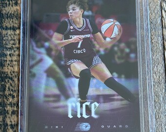 May include: A rectangular sports trading card featuring a basketball player in a black and white uniform with the number 7, holding a basketball. The card displays the text RYAN FORS, rice, KIKI, and GUARD, enclosed in a clear protective plastic sleeve.