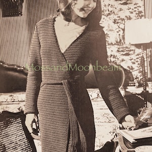 May include: A dark brown, long-sleeved crocheted wrap dress with a V-neck and a fringed sash. The dress is worn by a person in a vintage black and white photograph. The background features a striped wall and a patterned wall.