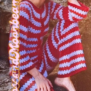 May include: A red and white striped crochet outfit, including a top and pants. The outfit is made of a soft, textured material. The text "Moss and Moonbeam" is written in a cursive font on the left side of the image.