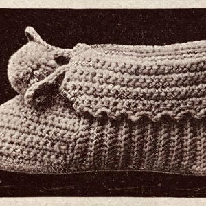 May include: A crocheted slipper with a ruffled edge and a bow on the top.