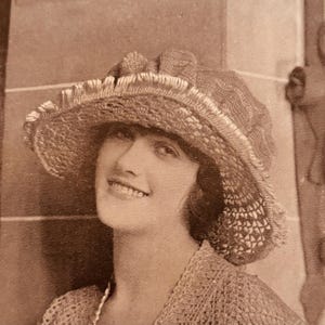 Puede incluir: Una mujer con un sombrero de ganchillo de ala ancha y un suéter de ganchillo.