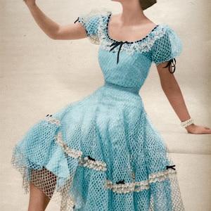 May include: A light blue vintage dress with a net overlay and white lace trim. The dress has short, puffed sleeves and small black bows. The model is wearing white earrings and a bracelet, holding a flower.