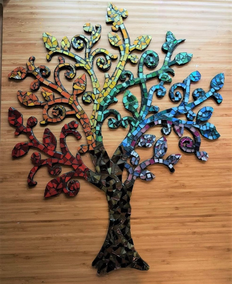 Puede incluir: Un arte de pared de &aacute;rbol de mosaico con un esquema de color arco&iacute;ris. El &aacute;rbol est&aacute; hecho de peque&ntilde;as baldosas de vidrio de colores y tiene un dise&ntilde;o caprichoso y org&aacute;nico.