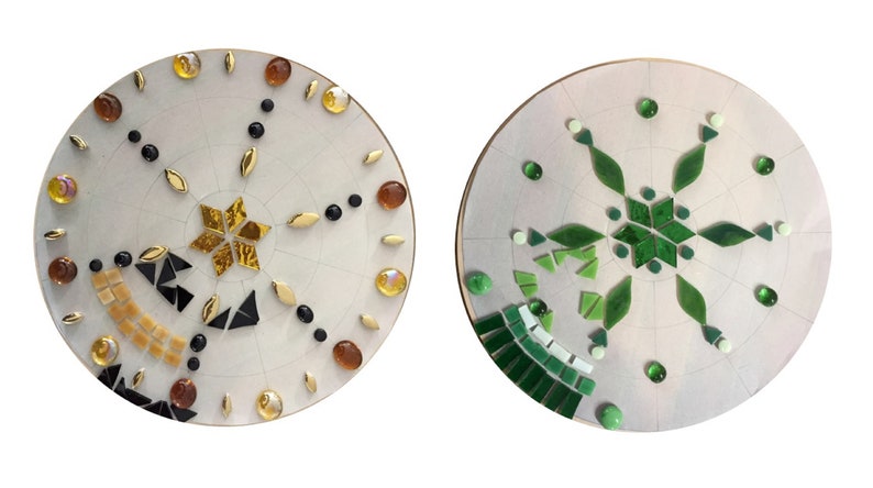 Puede incluir: Dos bases redondas de madera sin terminar, blancas, con dise&ntilde;os de mosaico de azulejos. Una base tiene un dise&ntilde;o de estrella dorada con azulejos negros y marrones. La otra base tiene un dise&ntilde;o de copo de nieve verde.