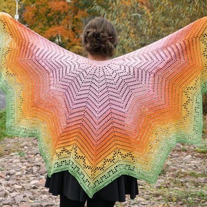Könnte beinhalten: Ein farbenfroher Häkel-Schal mit einem Sternmuster in Grün-, Gelb-, Orange-, Rosa- und Lilatönen.