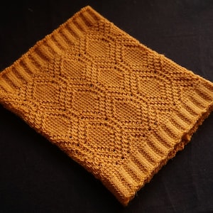 May include: A mustard yellow crocheted blanket with a diamond pattern.