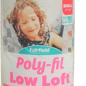 Może przedstawiać: Biały worek z watą do pikowania Fairfield Poly-fil Low Loft w rozmiarze małym, 45 cali na 60 cali. Worek jest różowy i biały i przedstawia uśmiechnięte młode dziewczę. Tekst na worku brzmi: "100% poliester Watolina do pikowania, Łatwa pielęgnacja, Mała, Lekka i oddychająca, Popularna watolina do pikowania i odzieży, Pikowanie maszynowe i ręczne, Niskie włosie, Niskoprofilowe podkreślenie ściegów, Nie mechaci się, nie przesuwa się i nie marszczy się, Bezwzględna gwarancja, Rozmiar mały: 45 cali x 60 cali (1,14 m x 1,52 m)"