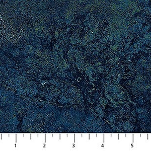May include: Close-up of a textured fabric with a mottled appearance in shades of dark teal, navy blue, and hints of green. A ruler is placed at the bottom, showing measurements in inches.