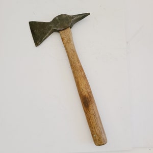 May include: A wooden-handled axe with a metal head. The axe has a sharp blade and a pointed end.