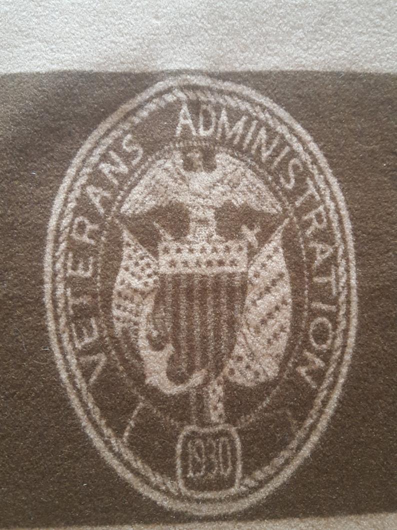May include: A brown oval seal with the words "Veterans Administration" and "1930" in white lettering. The seal features a white eagle with a shield and a crown.