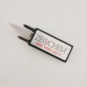 May include: A Zippo multi-tool with a small knife blade and two screwdriver heads. The tool is housed in a black and silver rectangular case with the text "ZEOCHEM THE VERY BEST".