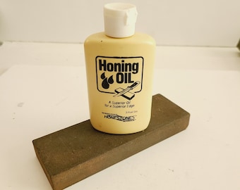 Vintage 1970's knife sharpening/honing oil with loose sharpening stone with a dual side medium/fine grit. Mostly full bottle Honestones