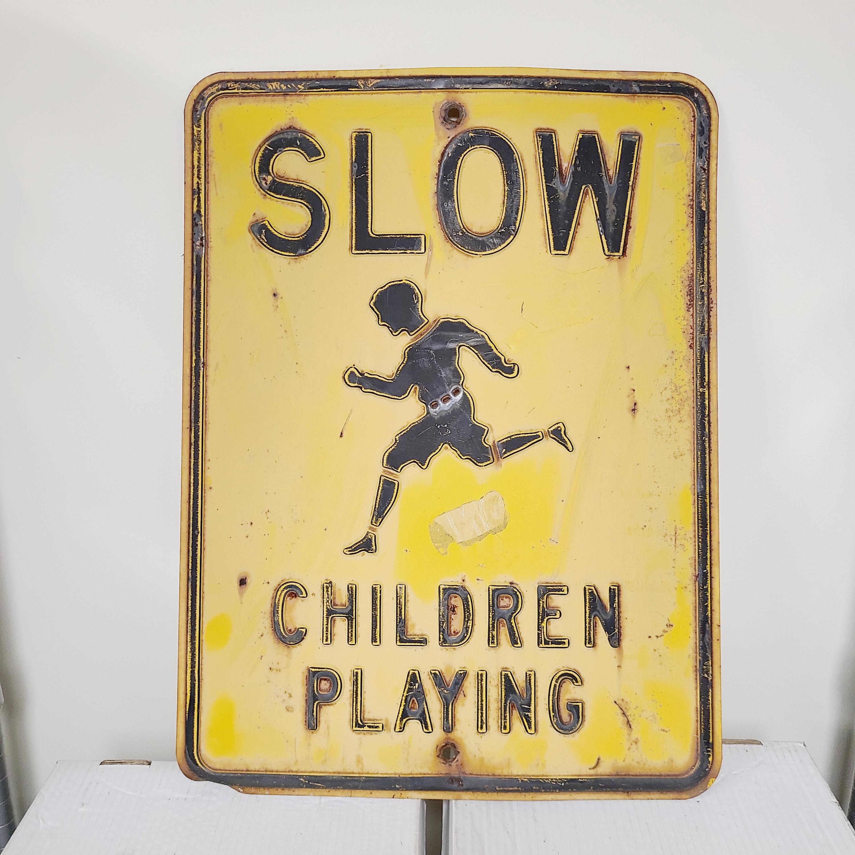Cartello con scritta Slow Children At Play (lingua italiana non