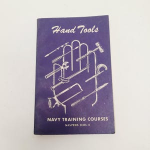 May include: A vintage navy blue booklet titled "Hand Tools" with illustrations of various tools. The booklet is part of the "Navy Training Courses" series, with the number NAVPERS 10306-A.