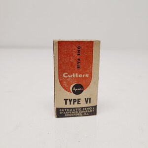 May include: A vintage box of "Cutters" pencil sharpener blades, "Type VI", from the Automatic Pencil Sharpener Company, Rockford, Ill. The box is rectangular with a red and tan color scheme and features the text "ONE PAIR".