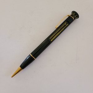 May include: A black mechanical pencil with a gold-colored tip and a ruler on the barrel. The ruler is marked in inches and fractions of an inch.