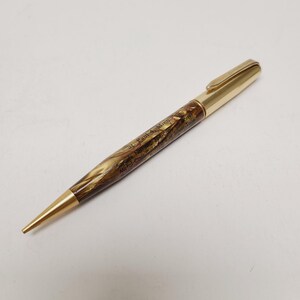 May include: A gold-toned pen with a marbled brown and tan barrel. The pen has a gold clip and tip. Text on the barrel reads "St. Paul 4, Minn." and other details. A classic writing instrument.