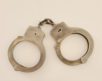 Vintage circa late 1920's pair of Peerless Handcuffs with no key. Serial# 58632 no post keyhole