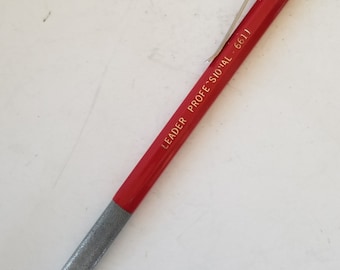 May include: A red mechanical pencil with a silver tip and a gold inscription that reads "Leader Professional 6611".