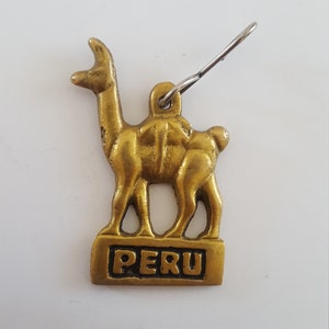 Vintage 1960's souvenir of Peru features a goldtone Alpaca with the word Peru, llama