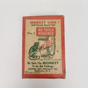 May include: A red and white box with the text "MONKEY LINK® Self-Closing Repair Link" and "NO TOOLS REQUIRED" on it. The box features a cartoon monkey holding a tire chain. The text "Be Sure The MONKEY Is on the Package" is also on the box.