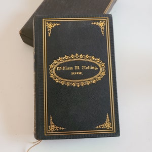 May include: A black leather-bound book with gold lettering and decorative accents. The title reads "William M. Nolting, 1912".