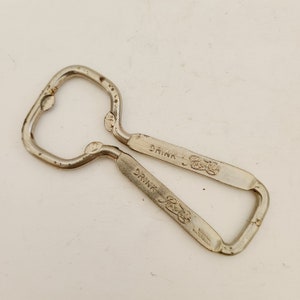 May include: A silver bottle opener with the words "Drink Pepsi-Cola" embossed on both sides.