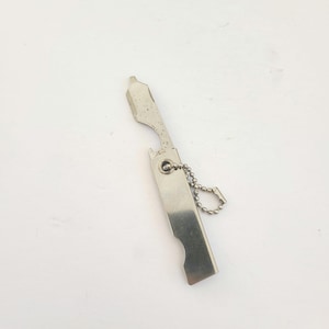 May include: A silver keychain tool with a bottle opener, a small blade, and a key ring.
