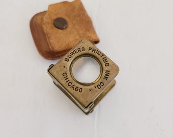 Vintage possibly antique spring activated loupe with advertising for Bowers Printing Ink Co. Brass, made in Germany, original leather case