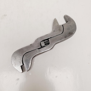 May include: Vintage adjustable wrench made by E.C. Stearns & Co. of Syracuse, NY, USA. The wrench is made of metal with a dark, aged finish. The text "E.C. STEARNS & CO. SYRACUSE N.Y. U.S.A." is stamped on the tool.