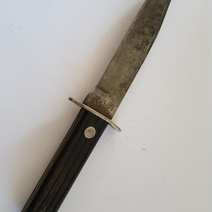 May include: A black-handled hunting knife with a silver blade. The blade is slightly curved and has a pointed tip.