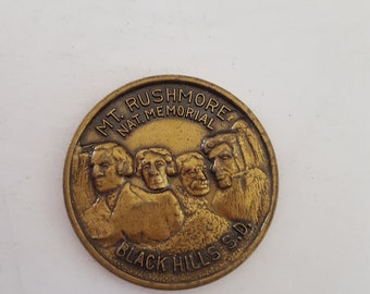 Vintage Mt. Rushmore coin with a quote on the obverse, Black Hills in South Dakota.