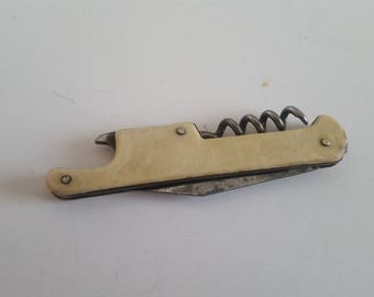 Vintage 1950's pocket bar ware tool, knife bottle opener and corkscrew off white plastic scales, some staining