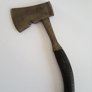 May include: A small, black-handled axe with a metal head. The axe has a black rubber grip with a textured pattern.