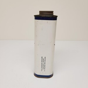 May include: A white metal can with a blue band around the top and bottom. The can has text that reads "U.S. STANDARD MEASURE CONTENT 1 QUART 7 1/2 POUNDS PER GALLON".