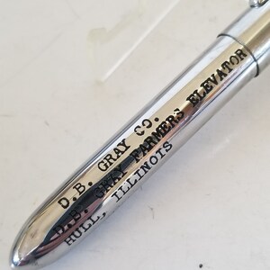Peut inclure: Un stylo argent&eacute; avec l'inscription "D.B. Gray Co. D.B. Gray Farmers Elevator Hull, Illinois" grav&eacute;e sur le c&ocirc;t&eacute;.