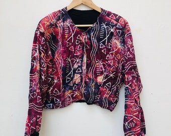 May include: A red, white, and blue patterned jacket with a button closure. The jacket has long sleeves and a cropped length.