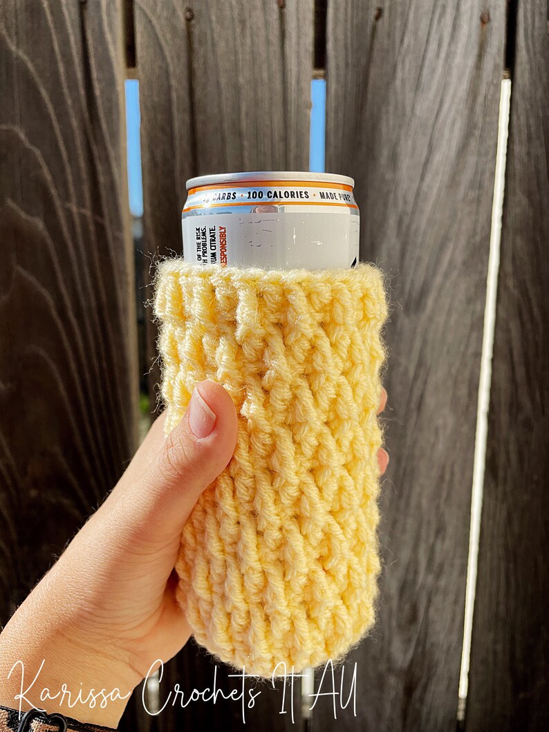 May include: A yellow crocheted can cosy, ideal for keeping your drink cold. The cosy is made with a simple stitch pattern and is easy to make.