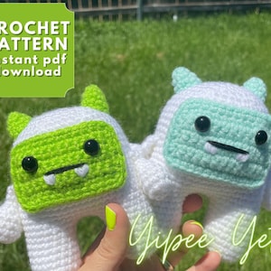 May include: Two crocheted Yeti amigurumi toys. One is green and the other is light blue. Both have white fur and black eyes. The text "Yippie Yeti" is written in the bottom right corner of the image.
